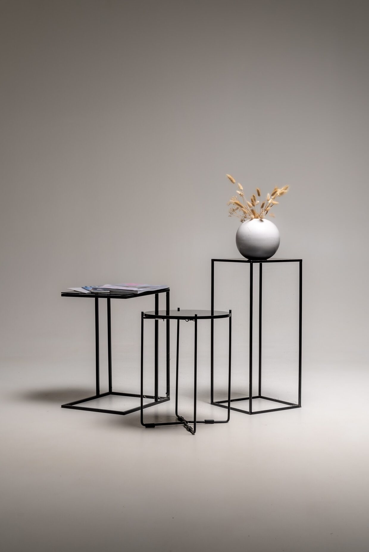Set aus schwarzen minimalistischen Beistelltischen aus Metall freigestellt im Fotostudio